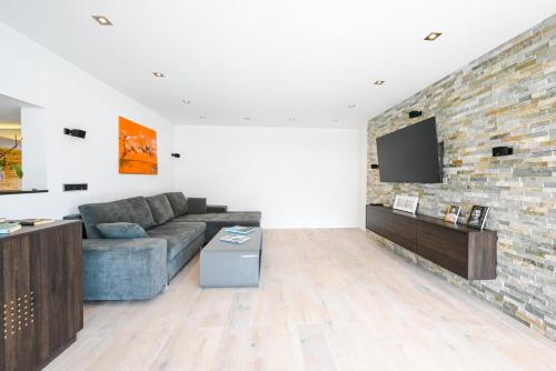 a living room with a couch and a brick wall at Alpin Chalet Arte in Söll