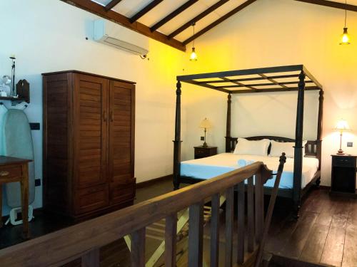 a bedroom with a bed and a dresser and a bed at Headman House Antique Villa - Ahangama in Ahangama