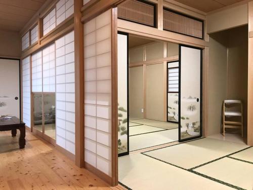 菊川市SOZENSYA 駅、高速インターに近い新築日本家屋です。庭が広く、BBQも楽しめます。的一间设有滑动玻璃门的房间,里面配有椅子
