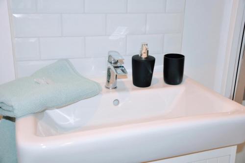a bathroom sink with two cups on top of it at Dormir à Brioude - appartement 'esprit nature' in Brioude