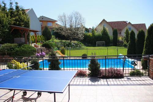una mesa de ping pong azul frente a una piscina en M&D Wellness, en Kozármisleny
