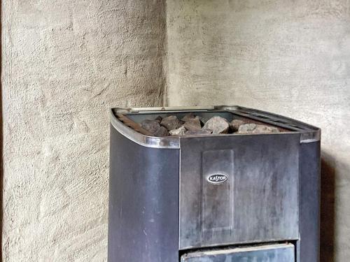 a trash can with rocks in it next to a wall at 4 star holiday home in Uppsala-By Traum in Uppsala
