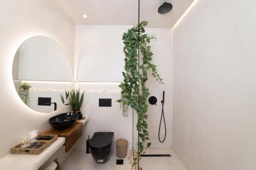a bathroom with a sink and a mirror at Gèa Athenian Suites in Athens