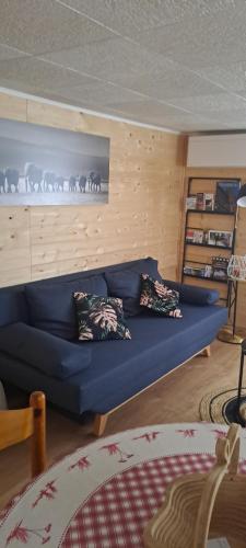un sofá azul en una sala de estar con una foto de animales en L'attrape rêve en Drusenheim