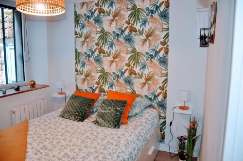 a bedroom with a bed with orange pillows at Dormir à Brioude - appartement 'esprit nature' in Brioude