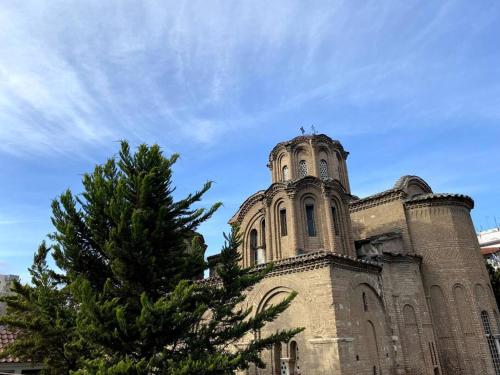 an old church with a pine tree in front of it at Cute 2bdrm in Salonica Center in Thessaloniki