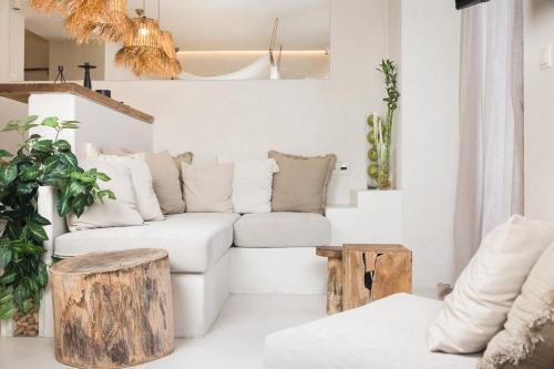 a living room with a white couch and wooden stools at Gèa Athenian Suites in Athens
