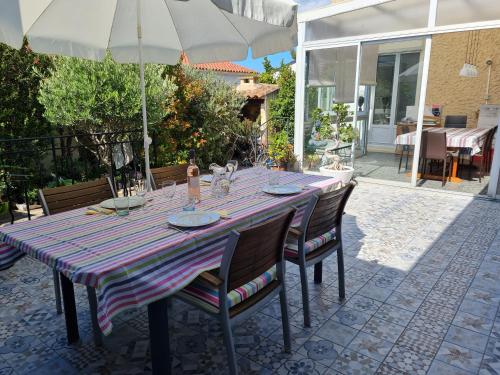 a table with chairs and an umbrella on a patio at La Med in Carry-le-Rouet