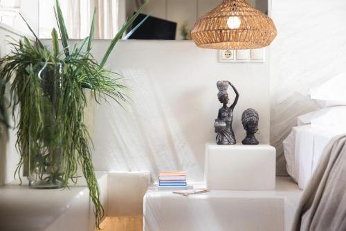 a room with two plants and a lamp on a table at Gèa Athenian Suites in Athens