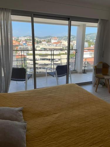 une chambre avec un grand lit et une grande fenêtre dans l'établissement Paca properties -EC14- Appartements T2 - Cannes, à Cannes