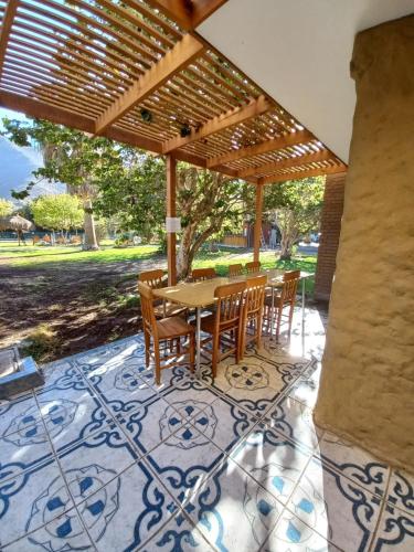 a wooden table and chairs under a wooden pergola at Hotel Naturaleza Vertientes de Elqui in El Molle