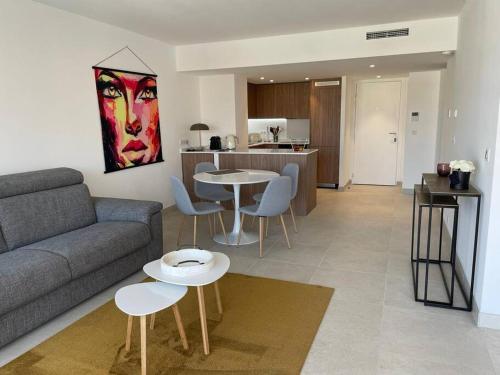 Il comprend un salon avec un canapé et des tables ainsi qu'une cuisine. dans l'établissement Paca properties -EC14- Appartements T2 - Cannes, à Cannes