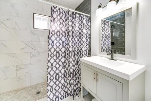 y baño con ducha, lavabo y espejo. en Updated Royal Oak Home Rental Near Downtown! en Royal Oak