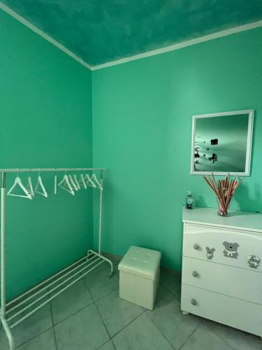 a bedroom with green walls and a dresser and a drawer at Il mondo di Leo in Tocco da Casauria