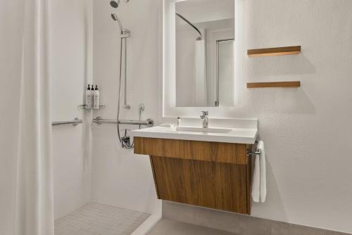 uma casa de banho com um lavatório, um espelho e um chuveiro em Delta Hotels by Marriott Orlando Celebration em Orlando