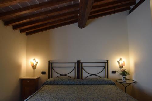 a bedroom with a bed and two lights on the wall at Relax in Chianti IL BORGO 8 in Montespertoli