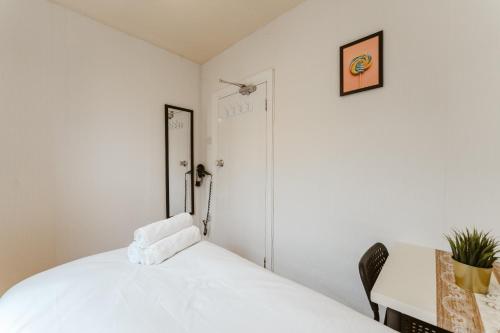 a bedroom with a white bed and a desk at Great Rooms in Plaistow in London