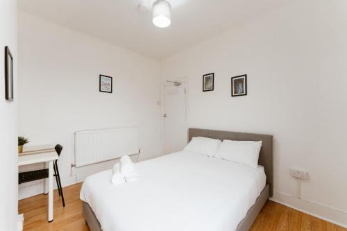 a white bedroom with a white bed and a desk at Great Rooms in Plaistow in London