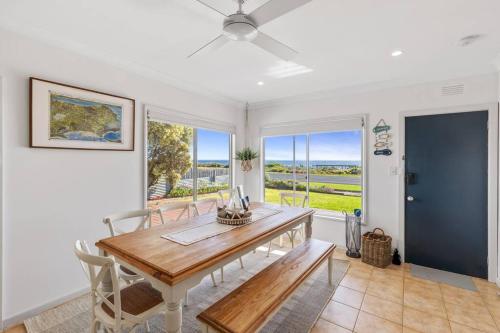 Un comedor con mesa y sillas de madera. en Oceanfront Odyssey, en Portarlington