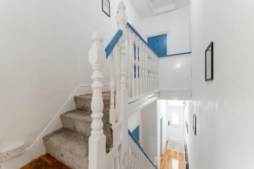 a white staircase with blue accents in a house at Great Rooms in Plaistow in London
