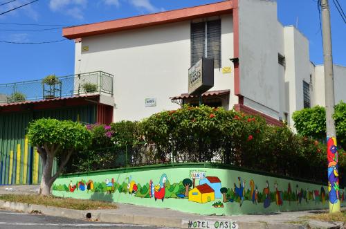 a wall with a mural on it in front of a building at Hotel Oasis in San Salvador