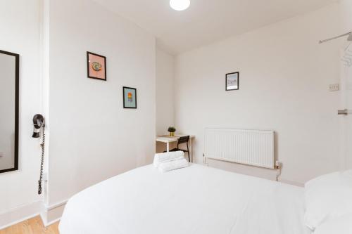 a white room with a bed and a phone at Great Rooms in Plaistow in London