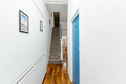 a staircase in a house with a blue door at Great Rooms in Plaistow in London