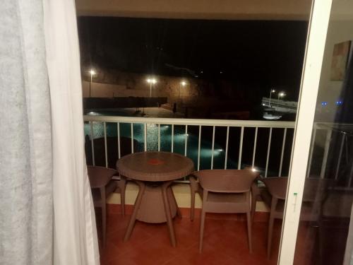 una mesa y sillas en un balcón por la noche en بورتو السخنه en Ain Sokhna