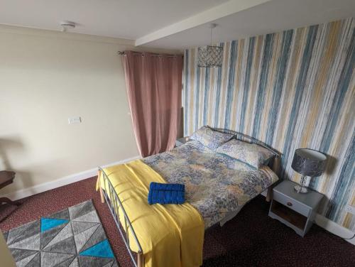 um quarto com uma cama com um cobertor amarelo em Antrim Heights BnB em Antrim