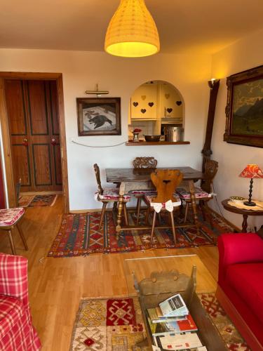 a living room with a table and a red couch at La casetta di Crans in Crans-Montana