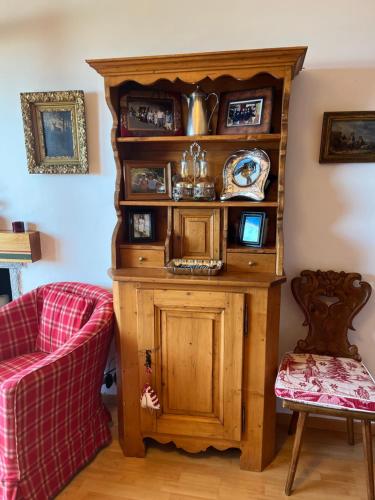 a wooden book shelf in a room with a red couch at La casetta di Crans in Crans-Montana