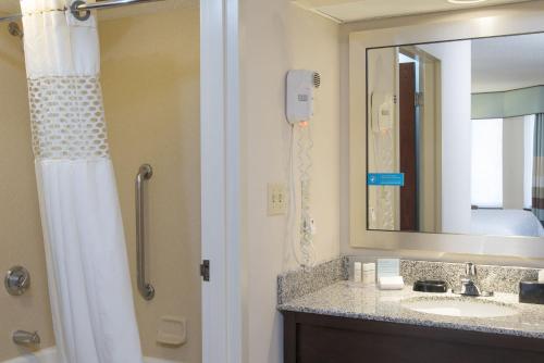 a bathroom with a shower and a sink and a mirror at Hampton Inn & Suites Kokomo in Kokomo