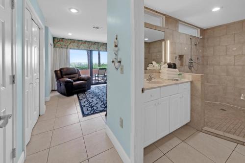 y baño con lavamanos, ducha y silla. en Aegean 120 - Beach Front 2 Bedroom, en Destin