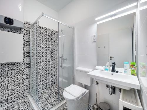 a bathroom with a shower and a sink and a toilet at Central and New apartment with AC in Budapest