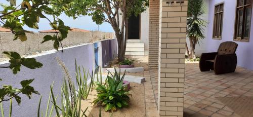 eine Terrasse mit einem Stuhl und Pflanzen neben einem Gebäude in der Unterkunft Casa Grande in Galinhos