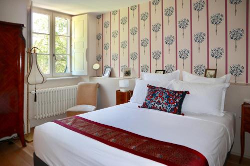 a bedroom with a large white bed with floral wallpaper at La Feuillaie in Saint-Ay