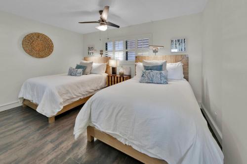 Un dormitorio con dos camas y un ventilador de techo. en Aegean 211 - Updated 2nd Floor Aegean Property, en Destin