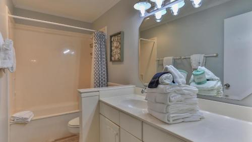 Un baño blanco con lavabo y espejo. en Aegean 210 - Updated 2 Bedroom 2 Bath at the Aegean, en Destin