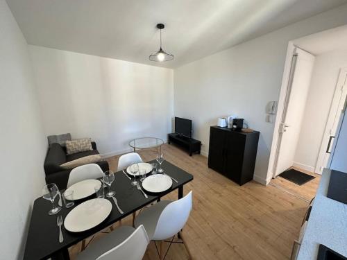 sala de estar con mesa negra y sillas blancas en T3 Capitole-Climatisation-Balcon en Toulouse