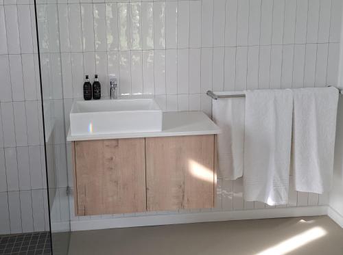 a bathroom with a white sink and white towels at KARENINA'S Self-catering Accommodation in Riebeek-Kasteel