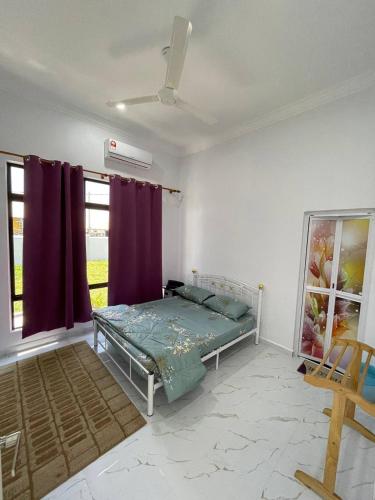 a bedroom with a bed in a room with purple curtains at Homestay PCB Villa MamaKaya in Kota Bharu