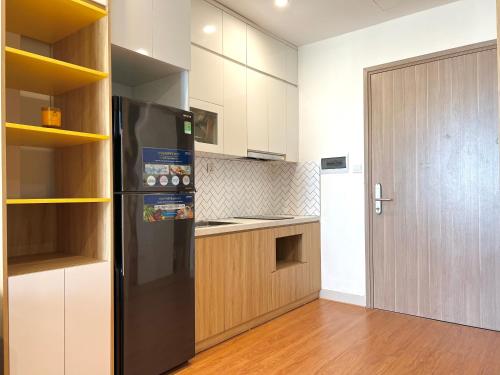 uma cozinha com um frigorífico preto e armários de madeira em Ocean View, Studio Ocean Park Đa Ton Gia Lam em Hanói