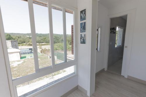 a room with large windows with a view at Casa Luna Rural Con Piscina y Jardín in Ourense