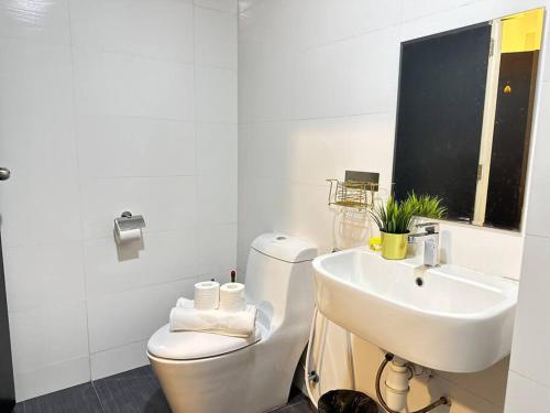 ein weißes Bad mit einem WC und einem Waschbecken in der Unterkunft Twin Galaxy 2 Bedroom Netflix 5-7 Pax Stylish Suite in Johor Bahru