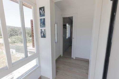 a hallway with white walls and large windows at Casa Luna Rural Con Piscina y Jardín in Ourense