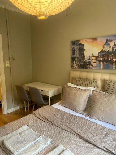 a bedroom with a bed and a table and a painting on the wall at Shared apartment close to the city center in Stockholm
