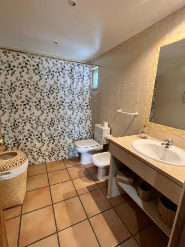 een badkamer met een wastafel, een toilet en een spiegel bij Real Village Praia Verde 142 in Praia Verde