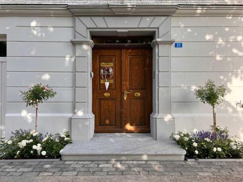 a wooden door on a white building with flowers at Haus zur Rose, St.Gallen, Bodensee, Säntis in Speicher