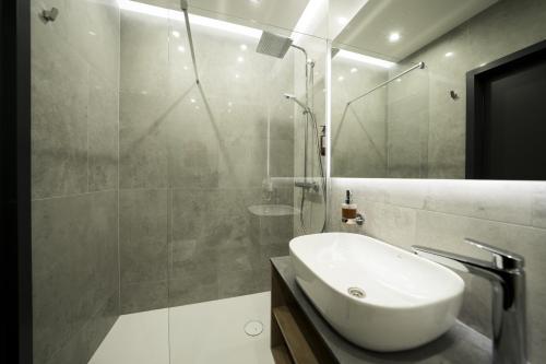 W łazience znajduje się biała umywalka i prysznic. w obiekcie Hotel Ambrozja w mieście Sierpc