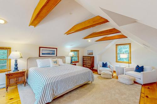 a large bedroom with a bed and a chair at Eagle's Nest in Yarmouth Port